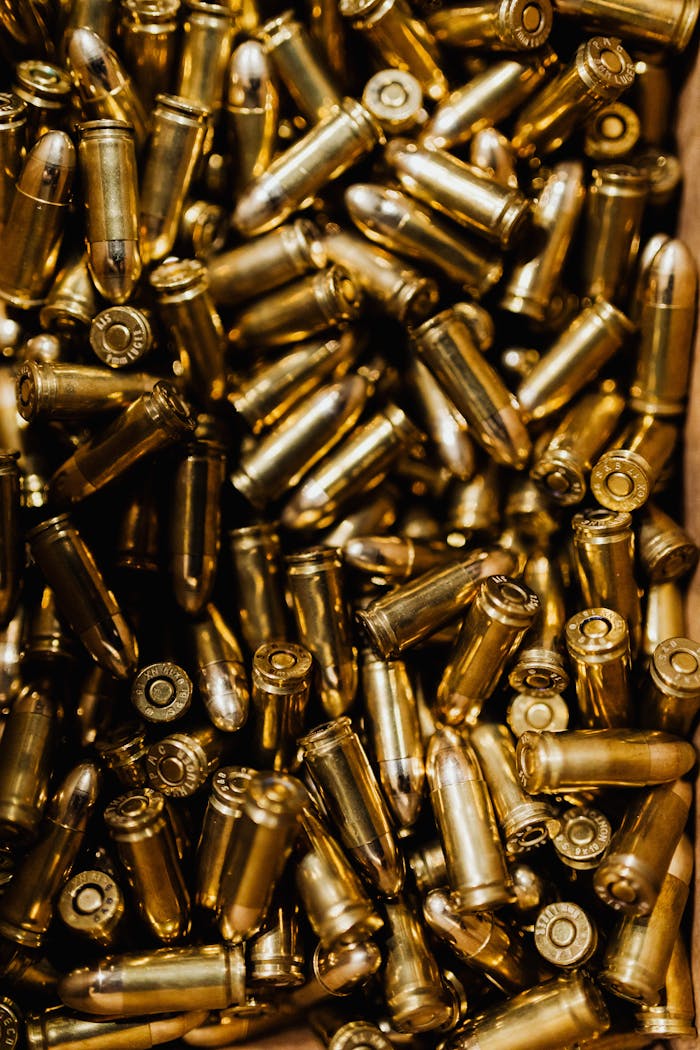 A detailed close-up of scattered brass ammunition bullets in a pile.